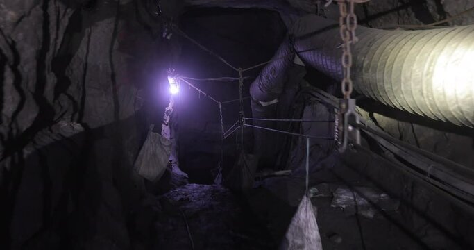 
The tunnel of the tanzanite mine which is hollowed out deep underground. Bags with a stone rise to the top and people work.