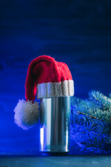 Aluminum craft beer can in a red Santa hat on a colored Christmas background . copy space