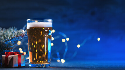 A glass of light beer on the table, a glowing blue background with a garland. Holiday festival