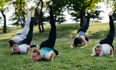 A group of people do yoga in the Park at sunset. Healthy lifestyle, meditation and Wellness