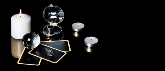 Christmas magical sessions with tarot cards, candle, ring and mirror isolated on black background. Mysterious Christmastide fortune telling. Magic atmosphere.