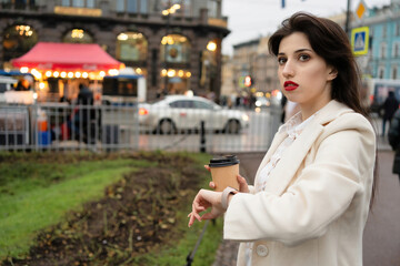 Girl looking at watch with coffee during break