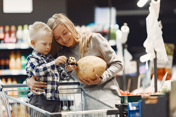 Family buying groceries. Mother in gray sweater.