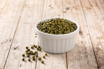 Green soy beans in white bowl on wooden table. 