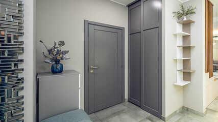 Entrance door  and wardrobe in luxury apartment. Moden interior. Grey colors. Decorative flower.