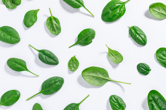 Seamless pattern made with green juicy baby spinach leaves on white background. Healthy food concept. Spinach wallpaper.
