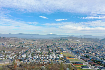 Peaceful town surrounded by trees with mountains as background