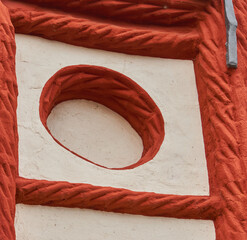 Detail of the abstractly decorated wall with white surface and red plait pattern of a medieval...