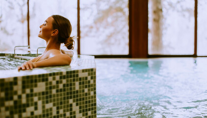 Young woman relaxing in the whirlpool bathtub at the poolside