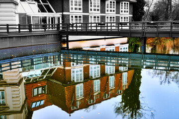 Abstractly processed colored reflection of a black and white building in the water of the river...