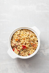 tabbouleh on small white bowl on ceramic background