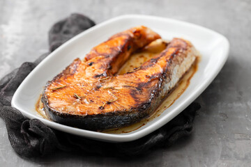 gried salmon on white dish on ceramic background