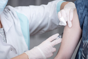 Close-up hands,nurses are vaccinations to patients using the syringe.Doctor vaccinating women in...