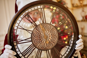 Naklejka premium Five minutes to New year or Christmas midnight. Happy Santa Claus shows on the clock