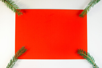 Christmas composition, flat lay. Blank red card, white frame and Christmas tree branches. Winter background top view, copy space