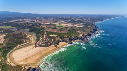  Aerial panorama of the village and Odeceixe beach, in summer overlooking the Algarve. Portugal 