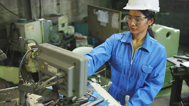 candid asian female Professional engineering wearing uniform and safety goggles Quality control, maintenance, check in factory, warehouse for factory operators