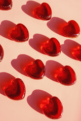 Small heart shaped jelly candies with hard shadows.