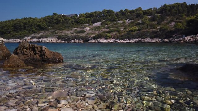 View of clear waters and smooth pebbles of Svitnja beach on the island of Vis in Croatia