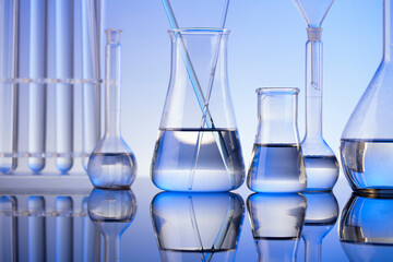 Coronavirus pandemic theme. Science research concerning fast covid tests and anti-covid vaccine. Beakers and test tubes on blue background.