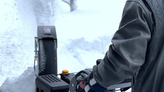 Man removing snow with a snow blower