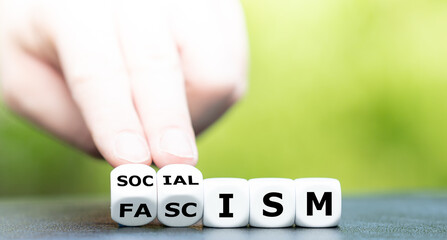 Hand turns dice and changes the word fascism to socialism.
