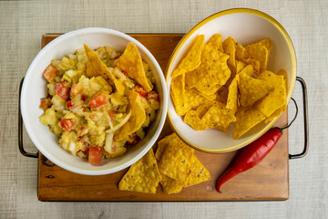 guacamole with tortillas on wooden table