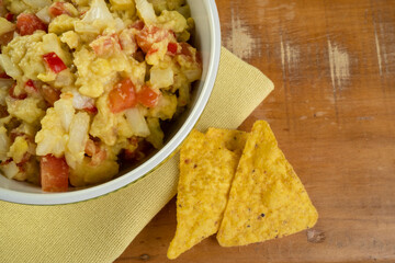 guacamole with tortillas on wooden table
