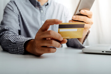 businesswoman hand using smart phone, tablet payments and holding credit card online shopping, omni channel, digital tablet docking keyboard computer at office in sun light