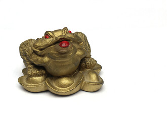 Statue of golden frog against white background.
