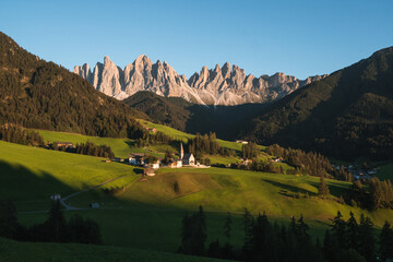 Beautiful view of the Puez Odle National Park and the Santa Magdalena Church at sunset, Dolomites, Italy