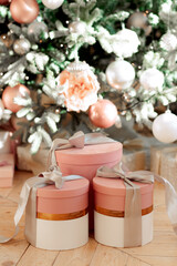 New Year's gifts under the tree, beautiful pink boxes with toys in light colors. Christmas presents.