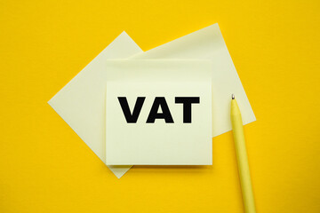 VAT - word on yellow stickers and a paper, yellow PeN on a yellow background. a bright solution for business, financial, marketing concept