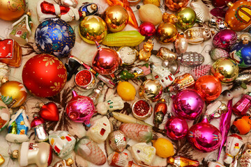 Christmas tree glass ornaments background. A close-up of a Christmas multi colored old and new baubles, animal, fairy tale and small houses ornaments ready to decorate a fir tree.