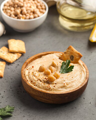 Hummus in a wooden plate with parsley and croutons. Dishes of chickpeas, a vegetarian dish.