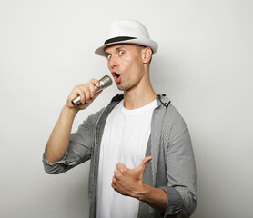 Time for karaoke. Young man singing with microphone