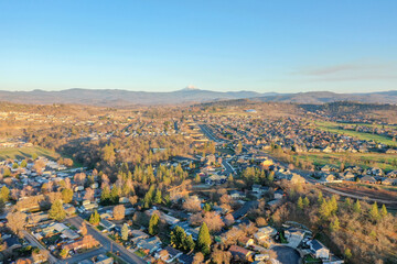 Peaceful town surrounded by trees with mountains as background