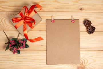 Christmas background with holiday decoration and card, red berries, fir branch and gifts top view