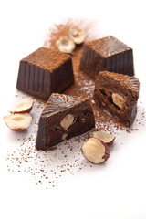 Broken chocolate candies with hazelnut inside on a white background