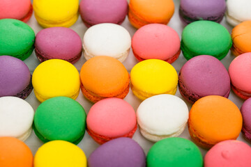 Fototapeta na wymiar Colorful French macaroons on the white wooden background close up