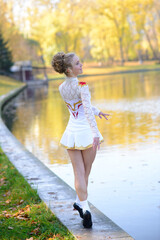 Naklejka premium Ballerina dancing in nature among autumn leaves.