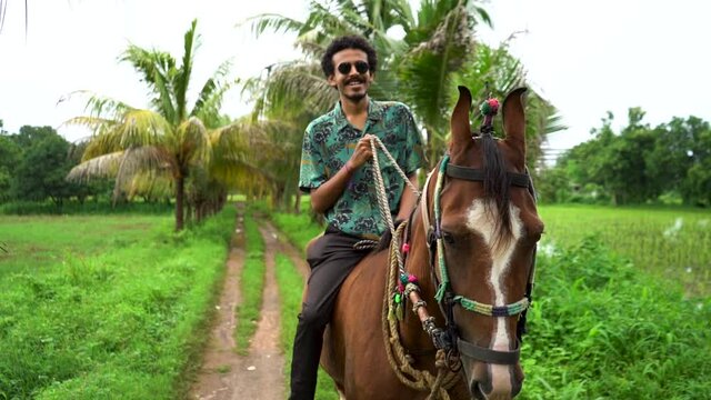 Young handsome man with brown horse. man riding horse