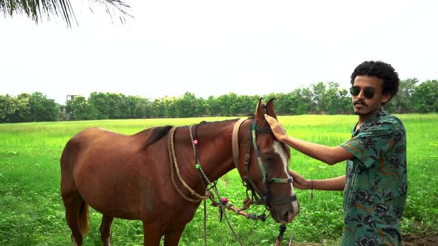 Young handsome man with brown horse.