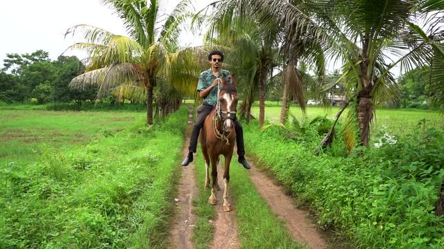 Young handsome man with brown horse. man riding horse
