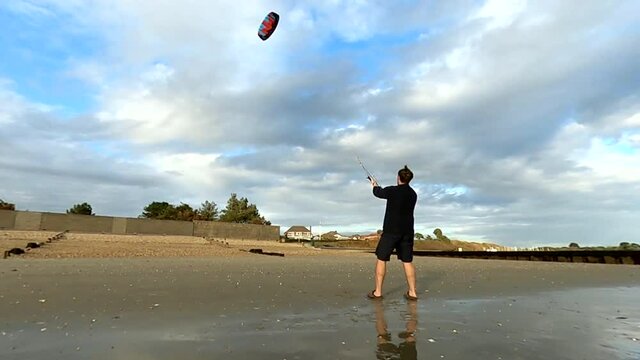 Man flying a power kite on the beach