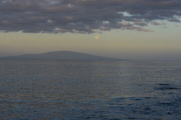 Moon setting at sunrise over a tropical Hawaiian island