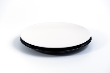 Empty White and Black plates stacked on white background side view