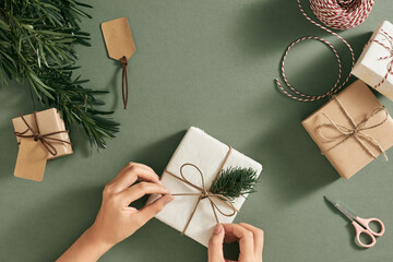 Female hands decorating presents at Christmas. Christmas concept.