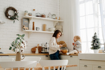 Mother and daughter cooking together in kitchen on Christmas Eve