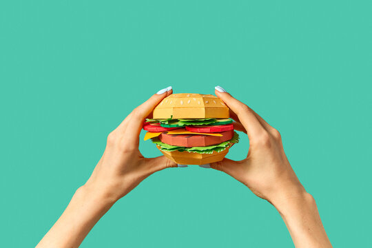 Hands hold paper craft hamburger.